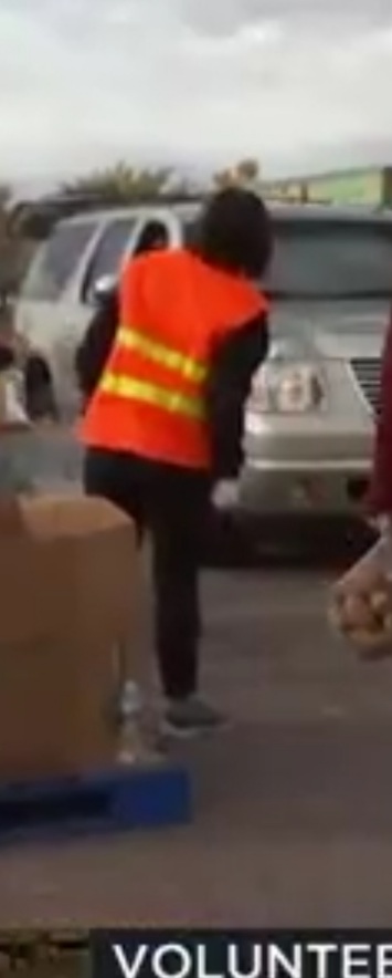 Volunteer angling her body and head to see a number on a car.